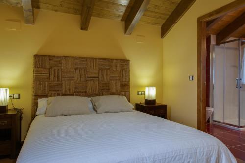 ein Schlafzimmer mit einem großen weißen Bett mit zwei Lampen in der Unterkunft Casa Rural O Fraginal in Guasillo