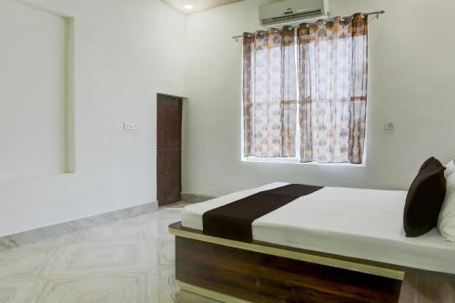 a bedroom with a bed and a window at OYO Hotel Royal Galaxy in Alwar