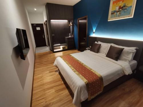 Sentral View Hotel Bintulu في بينتولو: غرفة نوم بسرير كبير وجدار ازرق