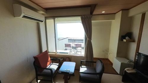 un soggiorno con due sedie e una finestra di HOTEL GREEN PLAZA SHODOSHIMA - Vacation STAY 81149v a Ikisue