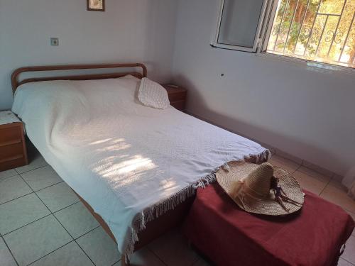 - une chambre avec un lit doté d'un chapeau dans l'établissement OLIVE VILA GEORGIA, à Filiatra