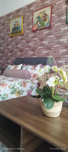 a bedroom with a bed and a table with a potted plant at SofiaSuite16, Plaza Azalea, Shah Alam in Shah Alam