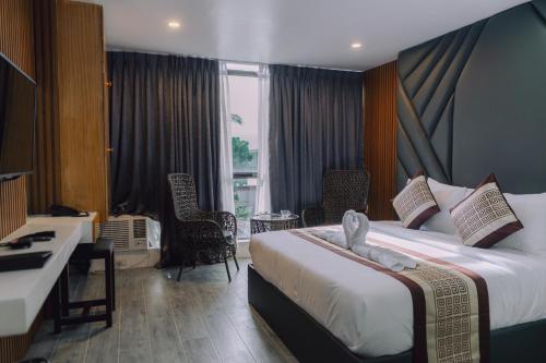 a hotel room with a large bed and a desk at Shine Boutique Hotel in Tagum