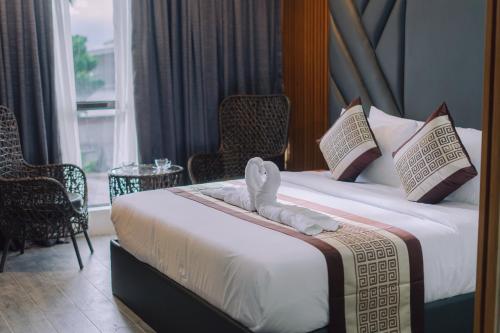 um quarto de hotel com duas camas e cadeiras e uma janela em Shine Boutique Hotel em Tagum