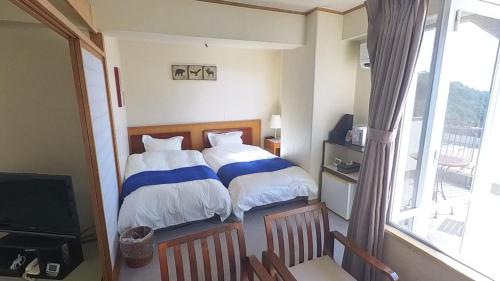 a bedroom with a bed with blue and white sheets at HOTEL GREEN PLAZA SHODOSHIMA - Vacation STAY 71488v in Ikisue