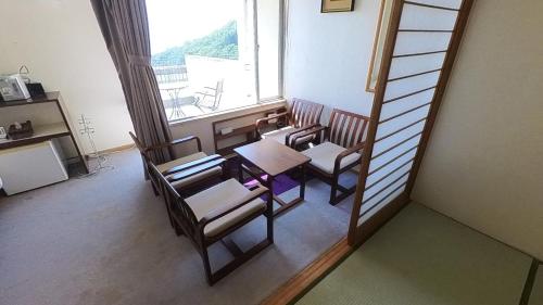 una camera con tavolo, sedie e finestra di HOTEL GREEN PLAZA SHODOSHIMA - Vacation STAY 71488v a Ikisue