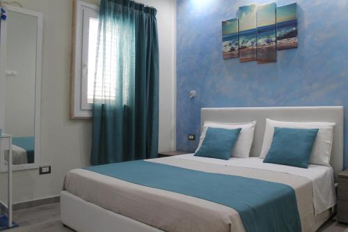 1 dormitorio con 1 cama grande y paredes azules en B&B Lizia, en Porto Cesareo