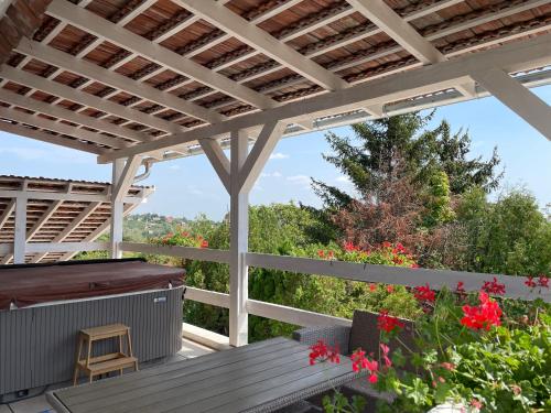 a deck with a pergola and a hot tub at Pecslux in Pécs