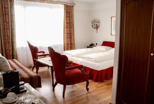 a bedroom with a bed and a table and chairs at Pension Suzanne in Vienna