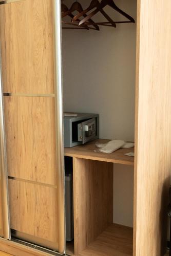 a closet with a microwave on a wooden desk at Pension a und a in Vienna