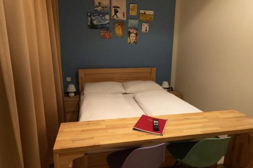 a bedroom with a bed and a table with a book on it at Pension a und a in Vienna