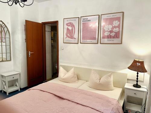 a bedroom with a bed and three pictures on the wall at Hotel Mariahilf München in Munich