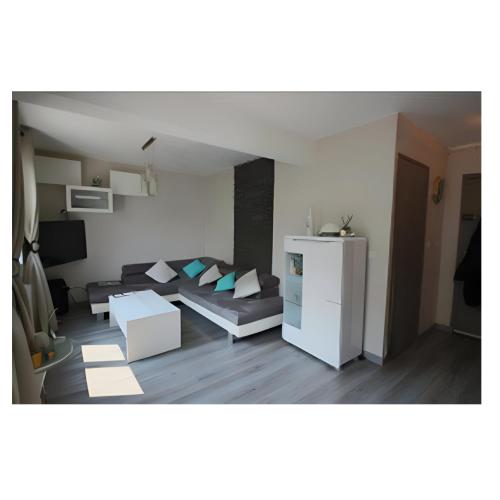 uma sala de estar com um sofá e uma mesa em Appartement Cosy- Emplacement Idéal pour les JO ! em Vanves