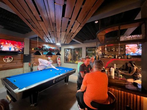 a group of people sitting at a bar with a pool table at PAPABO Adventure Village in Moalboal