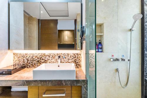 a bathroom with a sink and a shower at Poly Pivot International Aparthotel Guangzhou East Railway Branch - Free Shuttle Bus to Canton Fair Complex During Canton Fair Period in Guangzhou
