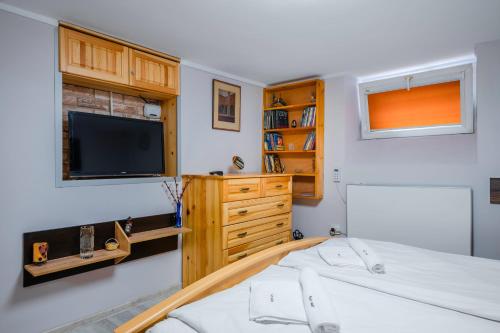 a bedroom with a bed and a tv on the wall at The Secret Spot 1BD Apartment in Sofia