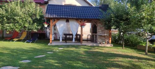 a gazebo with a table and chairs in a yard at Mašenka in Gospić