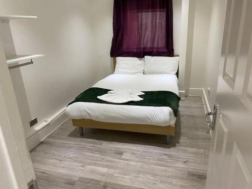 1 dormitorio pequeño con 1 cama con sábanas blancas en The w3 flat en Londres