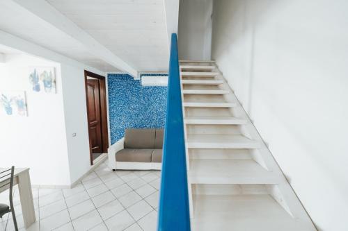 a white staircase in a room with a blue wall at Gioema in Borgo Vodice