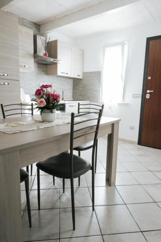 a kitchen with a table with chairs and flowers at Gioema in Borgo Vodice