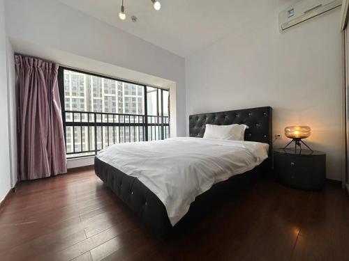 a bedroom with a large bed and a large window at Guangzhou Phantom Oasis Apartments - Canton Fair Exhibition Area in Guangzhou