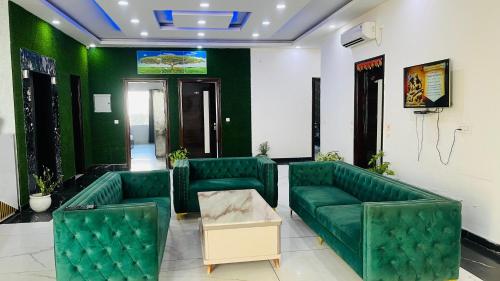 a waiting room with green chairs and a table at The God's Palace Resort in Meerut