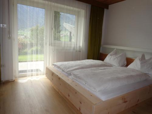 a bed in a room with a large window at Haus Talblick "Envy" Ferienwohnung in Naturno