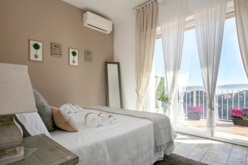 a bedroom with a white bed and a large window at Residenza il Punto in Perugia