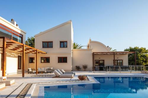 a villa with a swimming pool and a house at Angels Villa in Kambánion