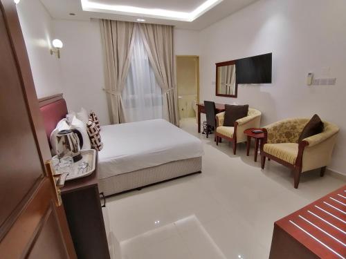 una camera d'albergo con letto e sedia di Nizwa Hotel Apartments a Nizwa