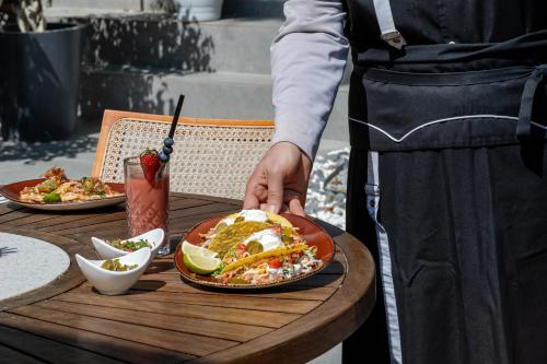 a person holding a plate of food on a table at Hotel Centro Bodrum in Bodrum City