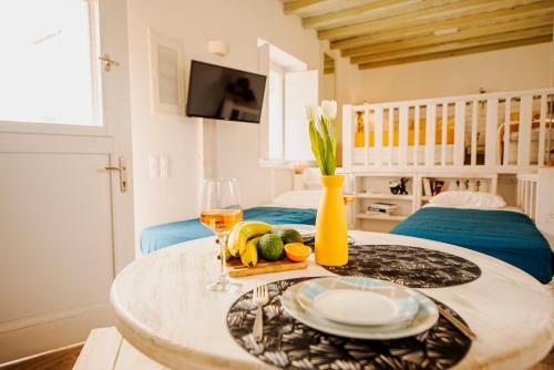 una mesa con un plato de comida y una copa de vino en Opus apartment en Agios Stefanos
