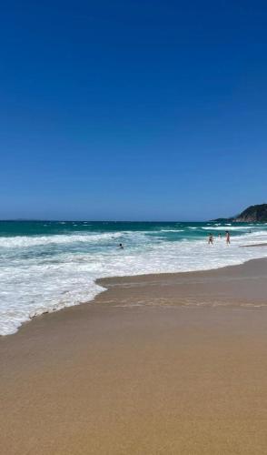 a group of people swimming in the water at the beach at VILLA VRACHOS Preveza in Vráchos