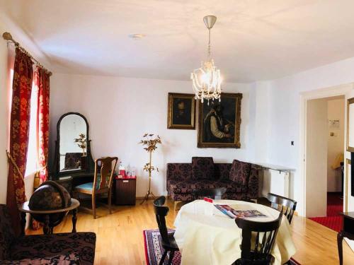 a living room with a table and a chandelier at Hotel Mariahilf München in Munich