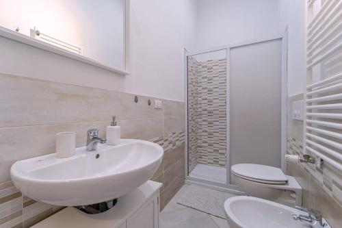 uma casa de banho branca com um lavatório e um WC em Savonarola Comfy Flat em Florença