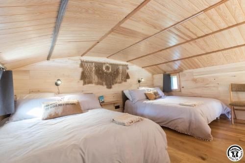 2 Betten in einem Zimmer mit Holzdecke in der Unterkunft Gîte cabane insolite Pyrénées in Sauveterre