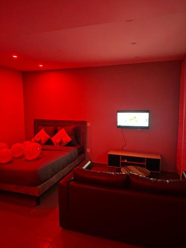 a red bedroom with a bed and a couch at Lov’SPA 2 in Fleury-Mérogis