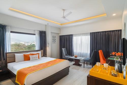 ein Hotelzimmer mit einem Bett, einem Schreibtisch und einem Zimmer in der Unterkunft Zone Connect by The Park,Udaipur in Udaipur