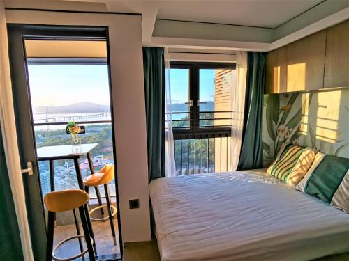 een slaapkamer met een bed en een balkon met uitzicht bij Interact China Fine Condo - Shenzhen Bay in Shenzhen