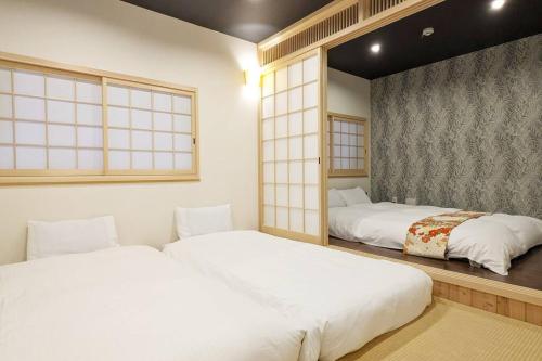 Kyoya Nobuhiro Reisen في كيوتو: سريرين يجلسون في غرفة مع نوافذ