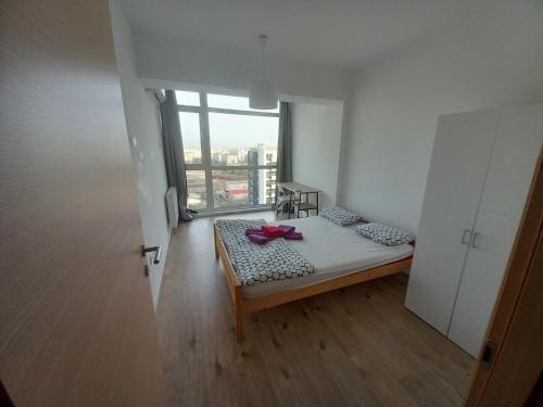 a room with a bed and a large window at Sofia & Natalia apartament in Bucharest