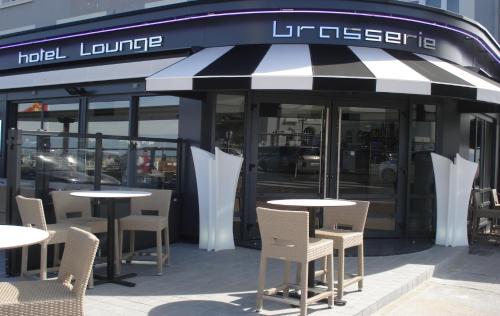 a restaurant with tables and chairs in front of a building at Les Embruns in Trouville-sur-Mer