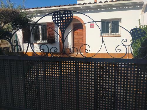 une clôture devant une maison avec un portail dans l'établissement Casita con jardin, parking, bicis, padel surf, à Ampurias