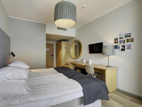 a bedroom with a bed and a desk and a television at Estonia Resort Hotel & Spa in Pärnu