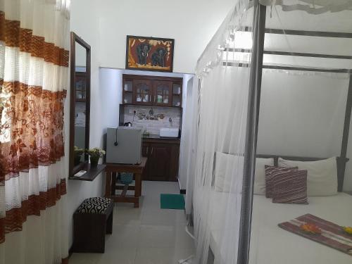 a room with a bed and a desk in it at Ging View Villa in Galle