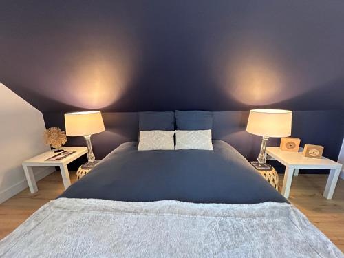 een slaapkamer met een groot bed met 2 lampen bij Parenthèse d'Opale in Wimille