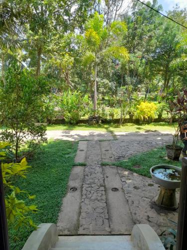 a garden with a stone path in the grass at Ging View Villa in Galle