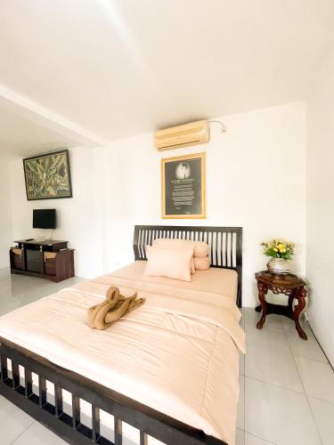 um quarto com uma cama grande e um bicho de peluche. em Villa Kamar Tamu Ngestiharjo em Jetis