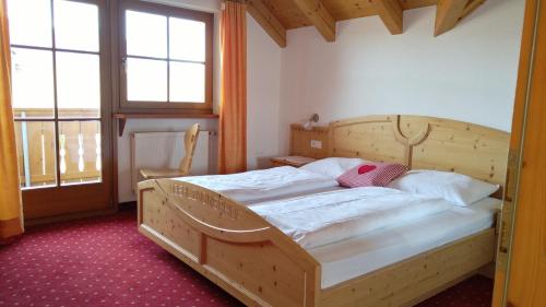 1 dormitorio con 2 camas y 2 ventanas en Oberlindnerhof en San Lorenzo di Sebato