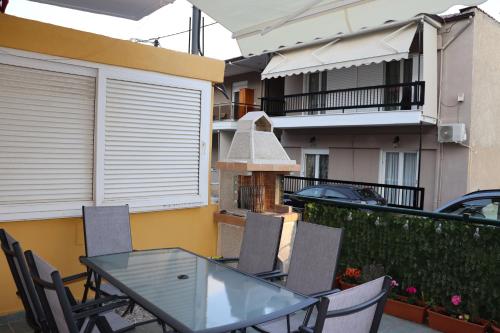 ネオス・マルマラスにあるApartman SIDRO Spacious with BIG balconyのガラスのテーブルと椅子付きのバルコニー